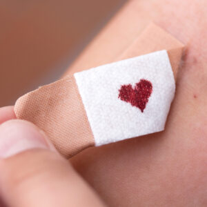Blutspenden Voraussetzungen: Pflaster beim Abziehen mit herzförmigem Blutstropfen in der Mitte