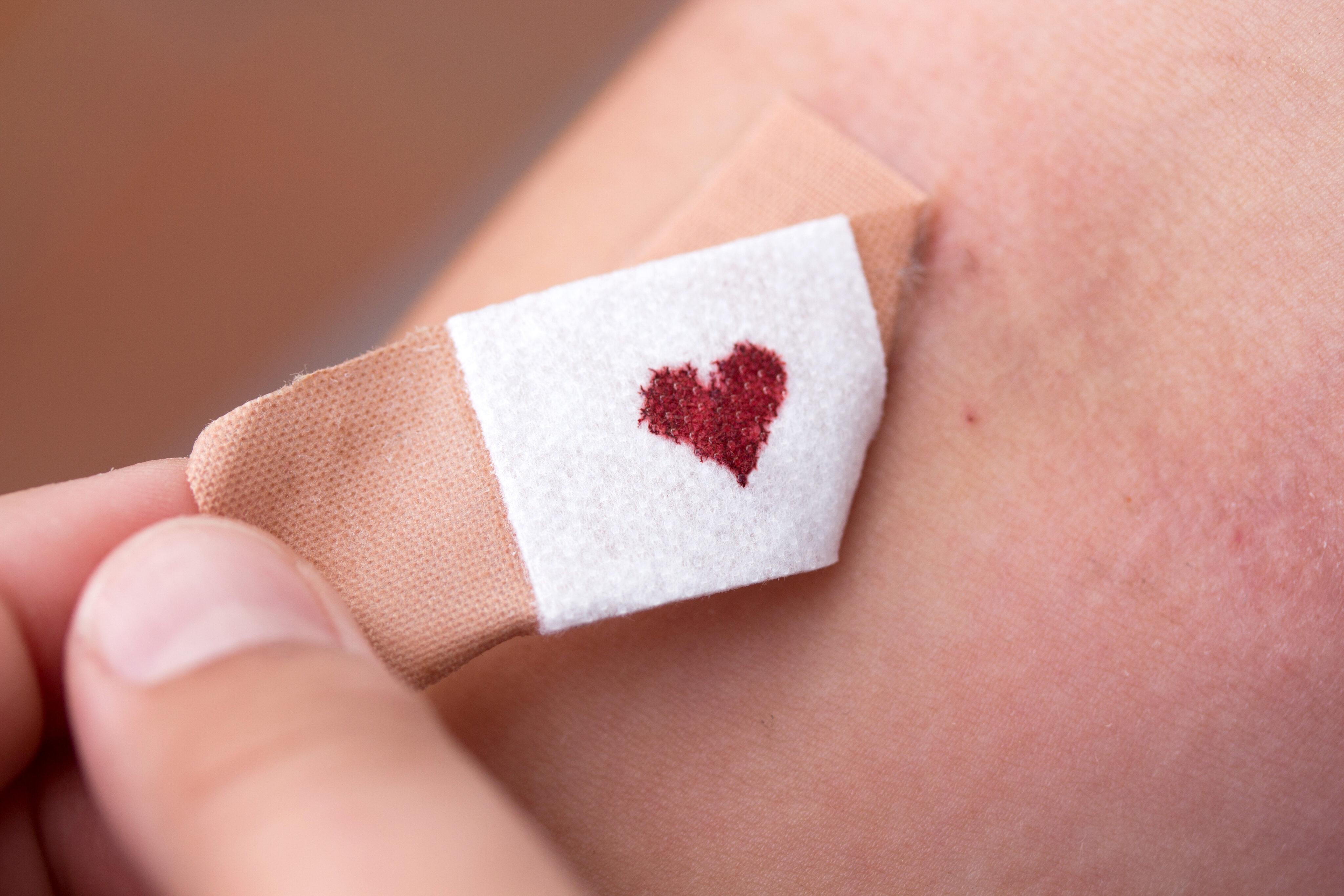 Blutspenden Voraussetzungen: Pflaster beim Abziehen mit herzförmigem Blutstropfen in der Mitte