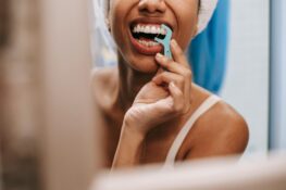 Entzündetes Zahnfleisch: Eine Frau benutzt eine Interdentalbürste, um ihre Zähne zu reinigen