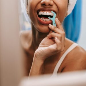 Gencives enflammées : une femme se brosse les dents avec une brosse interdentaire
